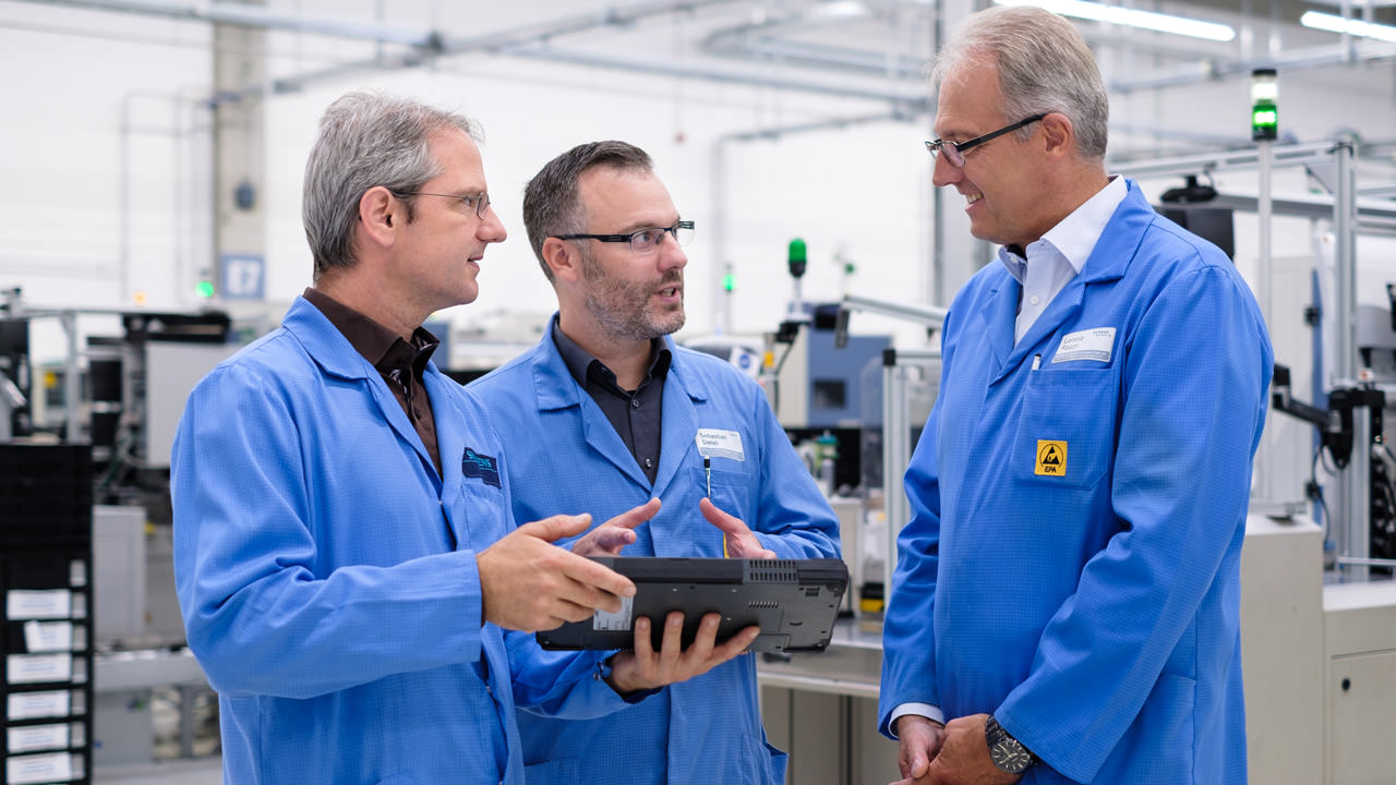 Factory manager Lorenz Rappl (right) catches up with the RTLS team – project manager Sebastian Dietel (center) and Hans-Jürgen Hufnagel – on new functions that are being developed together with the production staff.
