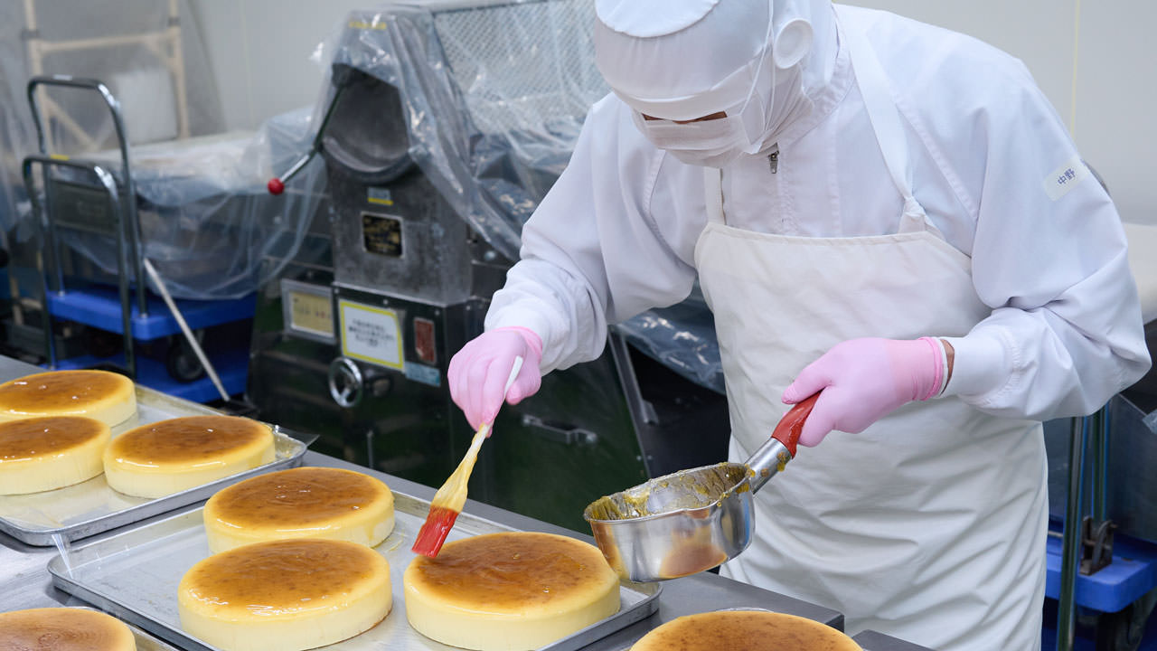 Famiel Confectionery sells a variety of cakes to hotels and restaurants nationwide in Japan. Photo shows the process of spreading jam on baked cheesecakes.